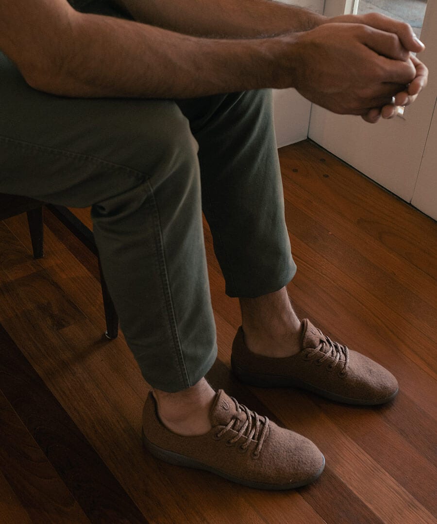 Homem usa calça cinza e Yuool Marrone em ideia de looks com tênis marrom